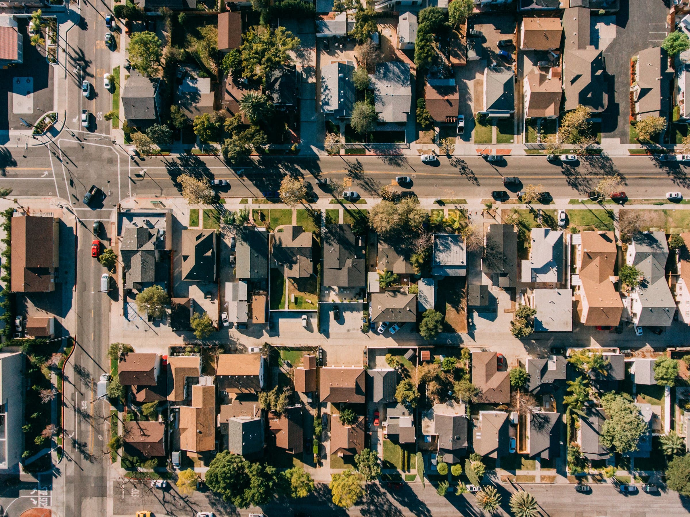 Rooftops, palms, and a grid of streets in the City of Orange, California, seen straight down from the air
